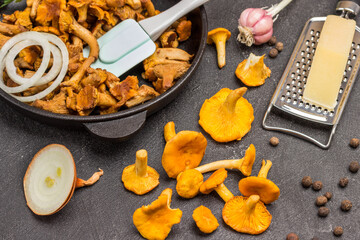 Raw chanterelles, oil in bottle and cheese on table.