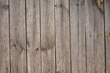 The old unpainted floor is made of gray - brown wooden boards. Natural wooden plank background without coloring