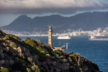 Vista del faro de Punta Carnero con el peñon de Gibraltar de fondo, Cádiz, Andalucía, España.