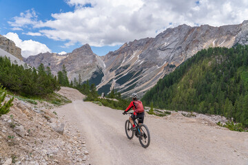 pretty active senior woman riding her electric mountain bike in the Fanes high Valley, part of...