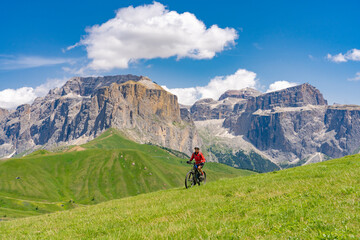 pretty active senior woman riding the famous Sella Ronda  mountain bike Trail  in Sella mountain...