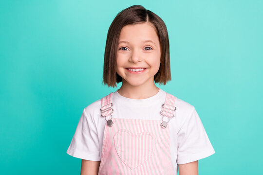 Photo of positive happy little small girl smile beaming good mood isolated on pastel teal color background