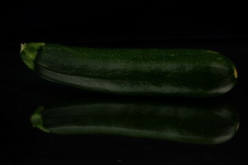 Zucchini on black background, courgette  low key.