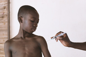 Little young African black boy getting his vaccine in a rural village in Mali.
