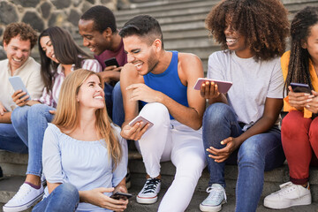 Group of young multiracial people having fun in the city with mobile phone - Millennial generation friends having social moment outdoor - obrazy, fototapety, plakaty