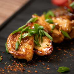 Fried seafood with green onions, mussels or clams on a plate. Close-up shot. Pan-asian cuisine, spicy food. Close-up shot. Soft focus.