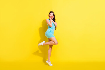 Fototapeta na wymiar Full size profile photo of fancy brunette hairdo young lady wear teal dress isolated on vivid yellow color background