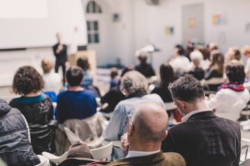Woman giving presentation in lecture hall at university.