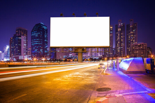 Blank billboard on light trails, street, city and urban in the night - can advertisement for display or montage product or business.
