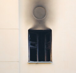 A burnt window of an apartment building after a fire