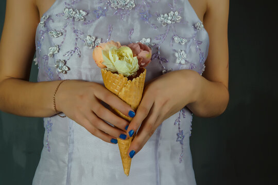 portrait of a young beautiful girl with flowers in a waffle cone in the form of ice cream - Powered by Adobe