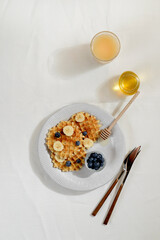waffles with blueberries and honey on a light background