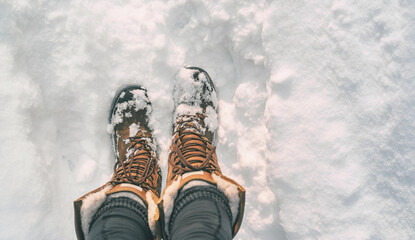 Winter hiking in Snow boots walking first person POV selfie of feet in deep cold snowfall in...