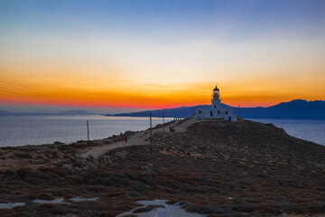 Silhouette of a lighthouse during orange sunset in Mykonos, Greece