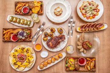 International food dishes set. Grilled Spanish entrecote, American hamburgers, nachos with Mexican guacamole, red tuna tartare and spinach and ham croquettes
