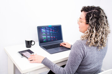 young woman analyzes financial charts in home office