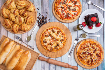 Individual pizzas, croissant tray, Venezuelan snack tray, chocolate cake with strawberries, pizza with mussels