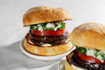 Close up of eggplant sandwich burger with feta cheese and cilantro. Plant based food concept