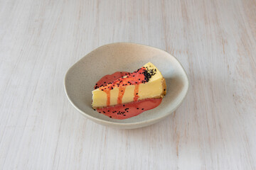 Cheesecake with strawberry and poppy seed smoothie on light wooden table