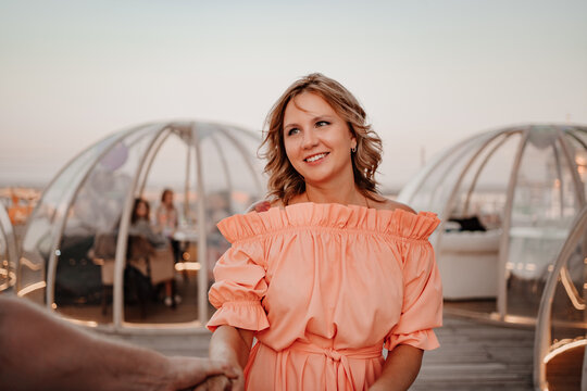 a man and a woman in love walk to a rooftop cafe on a date.