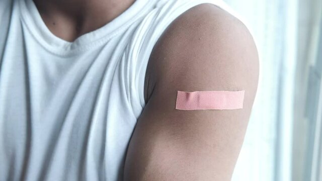 adhesive bandage on young man's arm 