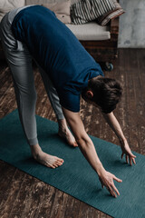 A young man performing yoga asanas and sports exercises to improve the strength and flexibility of the body