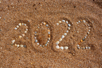 The figures for 2022 are made up of small shells. The concept of the New Year 2022. Summer holidays and sea trips
