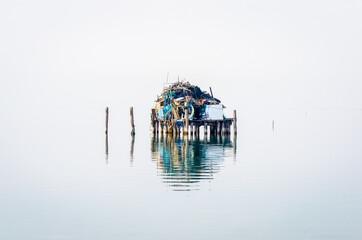 Un casone dei pescatori a Pellestrina nella laguna di Venezia si riflette nell’acqua in una giornata invernale © Andrea Vismara