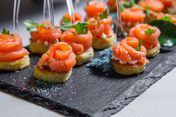 Canapes of red fish, bread, colored salt and herbs on skewers.