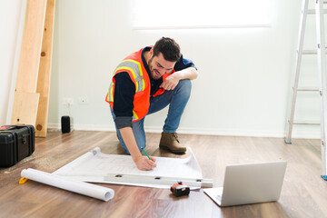 Happy contractor checking the blueprints