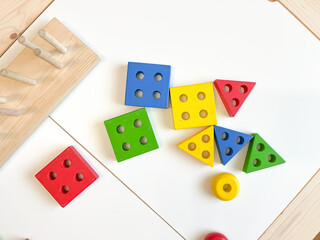 Toy made of wood for the study of shapes and colors. Useful game for a child on a white table. Montessori Education. Materials for the school. Materials on geometry. the concept of teaching children.