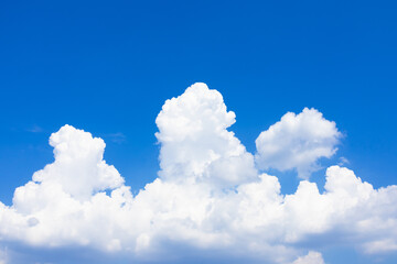 Naklejka na ściany i meble White cumulus clouds against a clear blue sky. Heavenly background.