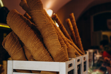 Conical waffle cups for ice cream. Sweet waffle cups in a wooden box.