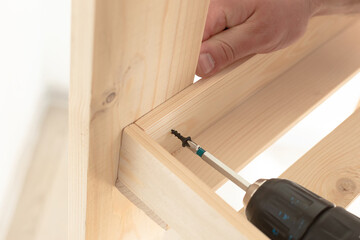 Wooden slats and working tools. Carpentry work. The self-tapping screw is screwed into the wooden...