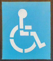 Newly painted handicapped parking space sign on asphalt.