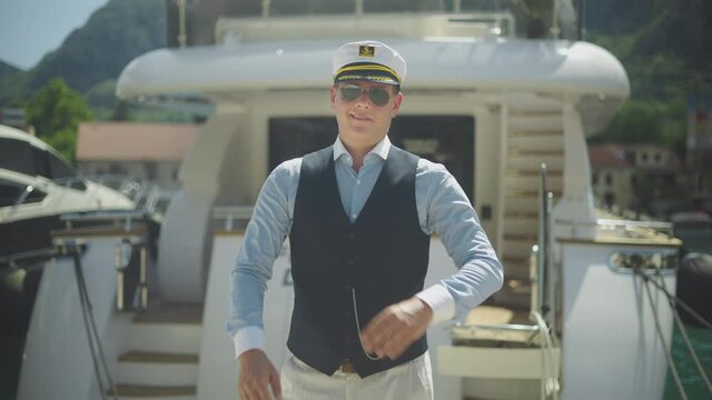 Zoom in shot of smiling captain of boat standing and crossing arms. Summer vacation at sea, sailing and travelling concept.
