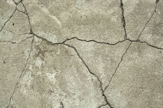 Cracks in the concrete floor. Abstract background.