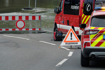 Absperrung und Verkehrsschild Verbot der Durchfahrt und Fahrzeuge der Feuerwehr vor überfluteter...
