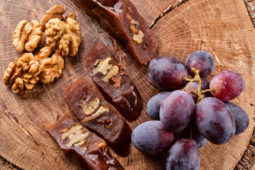 Churchkhela, national Georgian dessert made from grape juice and walnuts, composition on a wooden table