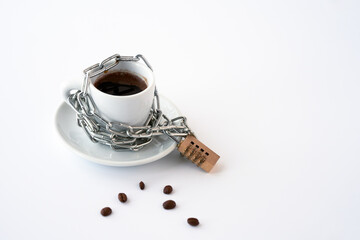 A white coffee cup is wrapped with a chain and locked with a combination lock. Copy space.
