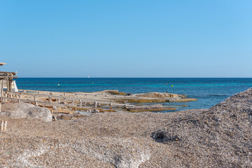 Rocky side of Migjorn beach on a sunny day in Formentera, Spain