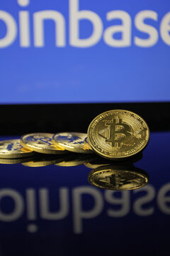 Bitcoin M&uuml;nzen mit Logo der Kryptob&ouml;rse Coinbase im Hintergrund