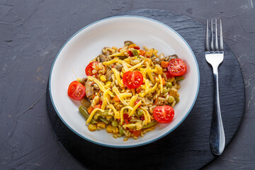Risotto with mushrooms in a plate on a gray background on black coasters and a fork.
