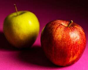 Red and Green apple on a pink background