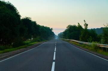 Calm empty asphalt road without cars at sunrise