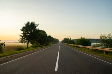 Fototapeta premium Calm empty asphalt road without cars at sunrise