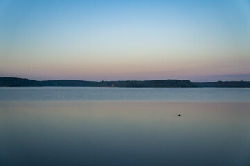 Calm beautiful sunrise over the lake with sky reflection in water