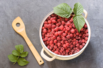 a full pan of ripe raspberries and a spoon for jam, a large harvest of healthy berries, a healthy diet. Favorite delicacy, preservation of Natural vitamins for the winter