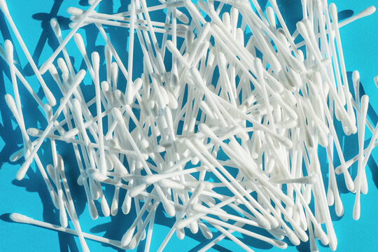 White cotton swabs or cotton buds are seen on blue background