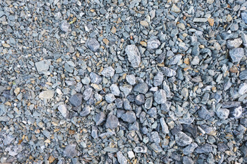 close-up photo of a pile of crushed stone with asbestos, poured on the road before laying asphalt